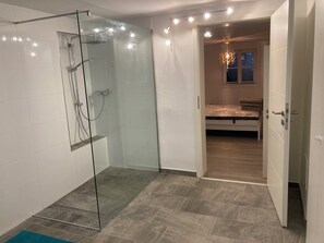 Enjoy a refreshing shower in this bathroom with a glass-enclosed shower area and handheld showerhead.