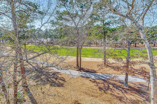A park with trees, a paved path, and a grassy area. - Dog-friendly Condo w/ Resort Perks in Calabash! (Calabash)
