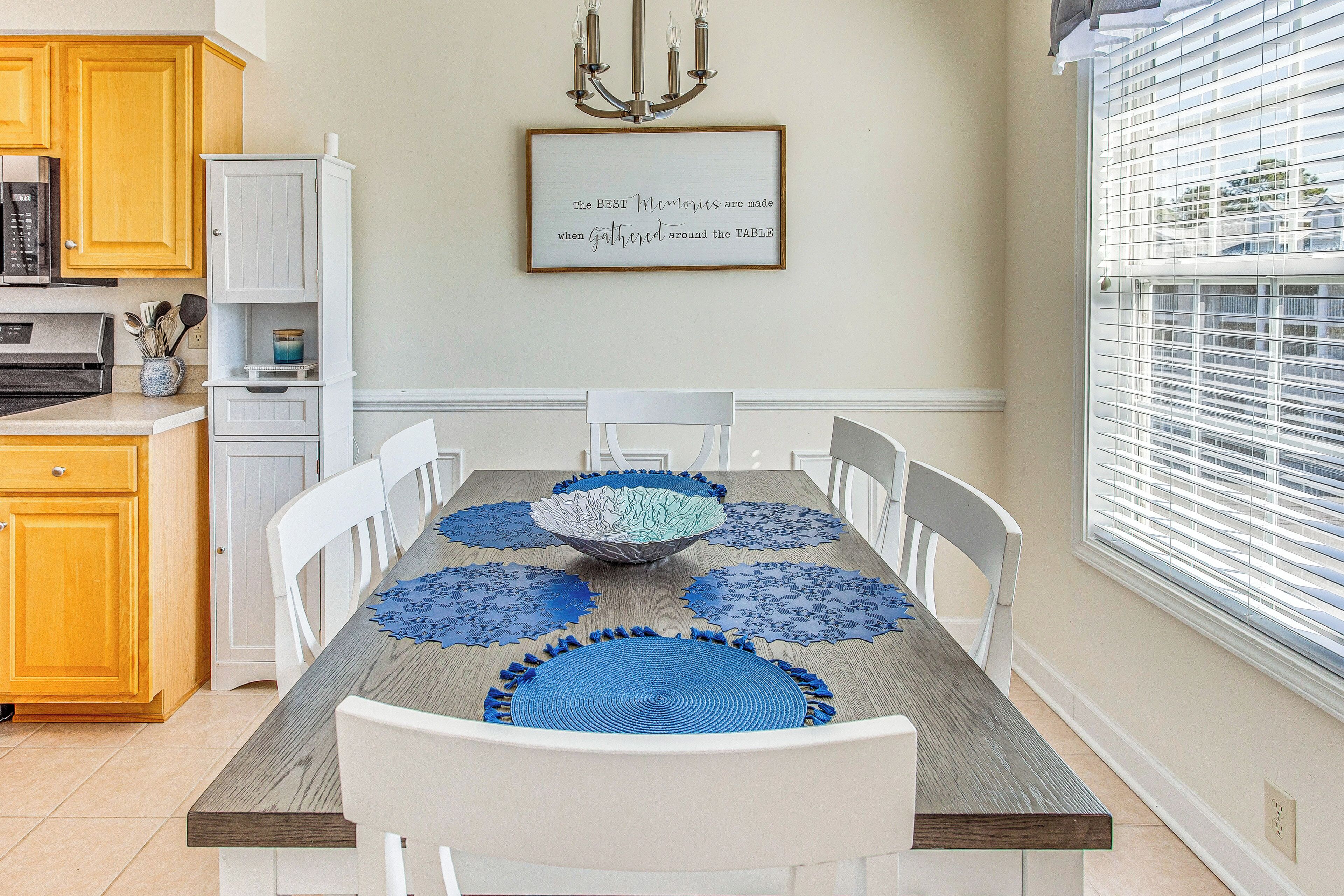 A dining area with a wooden table, white chairs, and a decorative centerpiece.