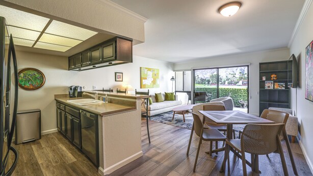 A modern kitchen with a central island, a dining area with a table and chairs, and a living room with a sofa and a coffee table. - Mtn-view Condo w/ Pool Access in Palm Springs! (Palm Springs)