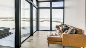 A modern living room with large windows, a leather sofa, and a view of a snowy landscape. - Hot Tub, 23 Mi to Grand Targhee: Luxe Retreat (Tetonia)