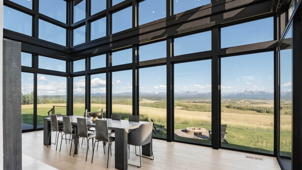 A spacious room with a large dining table and chairs, large windows offering a view of a grassy landscape and mountains. - Hot Tub, 23 Mi to Grand Targhee: Luxe Retreat (Tetonia)