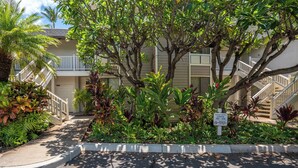 A residential building with a covered outdoor area, a staircase, and a sign indicating the number of units. - Grand Champions #147 Golf Course Views Full Kitchen AC In Bedrooms (Kihei)