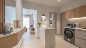 Eine moderne Küche mit Einbauwaschmaschine, Mikrowelle und Holzschrank.