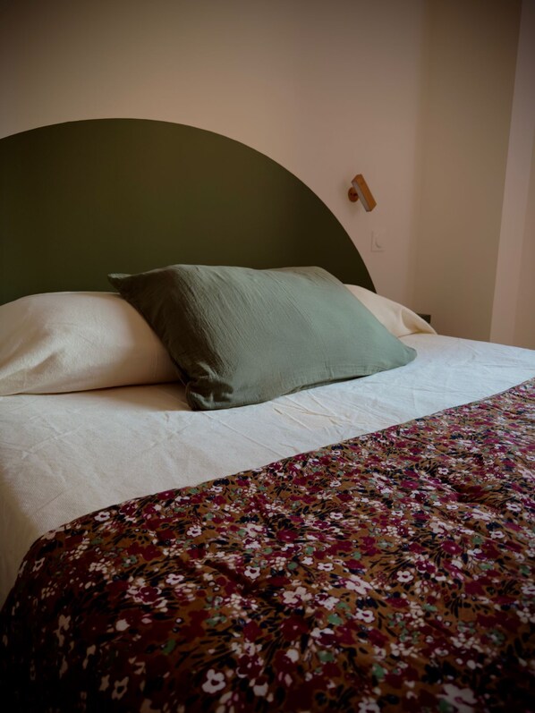 A bed with a green headboard, white pillows, and a floral-patterned bedspread. - L'auberge U PAMPASGIOLU (Galeria)