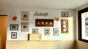 Una pared con varias fotos enmarcadas y un letrero que dice "Auberge".