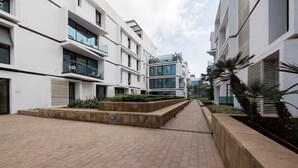 Un edificio moderno con varios balcones y un camino pavimentado.