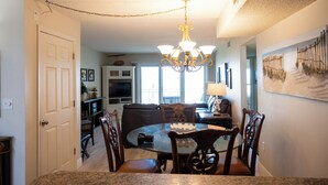A dining area with a chandelier, a round table, and chairs. - Beachfront Escape with Pool +Ocean & coastal Views (Saint Augustine)