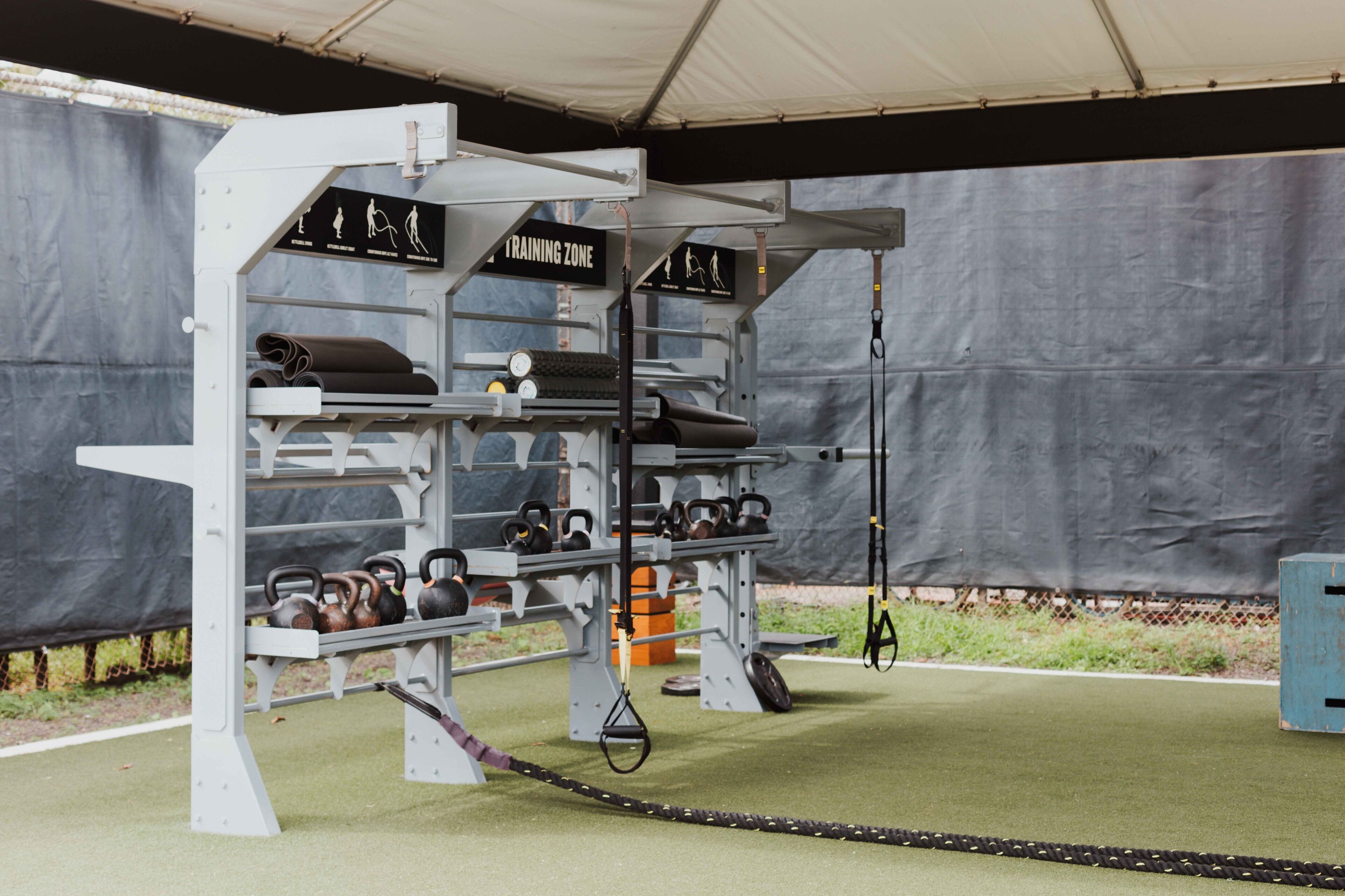 A gym with weightlifting equipment and kettlebells.