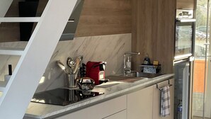 A modern kitchen with a built-in island, stainless steel appliances, and a glass door refrigerator. - 3* duplex apartment with balcony facing the sea (Sainte-Maxime)