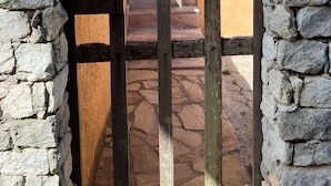 A stone wall with a wooden gate leading to a staircase.
