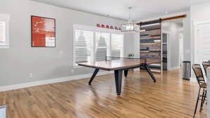 A spacious kitchen with a wooden table, white walls, and a modern pendant light. - Lucky Bachelor 5 Min to Broadway (Nashville)
