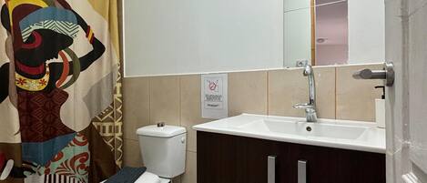 A bathroom with a toilet, sink, and shower curtain.