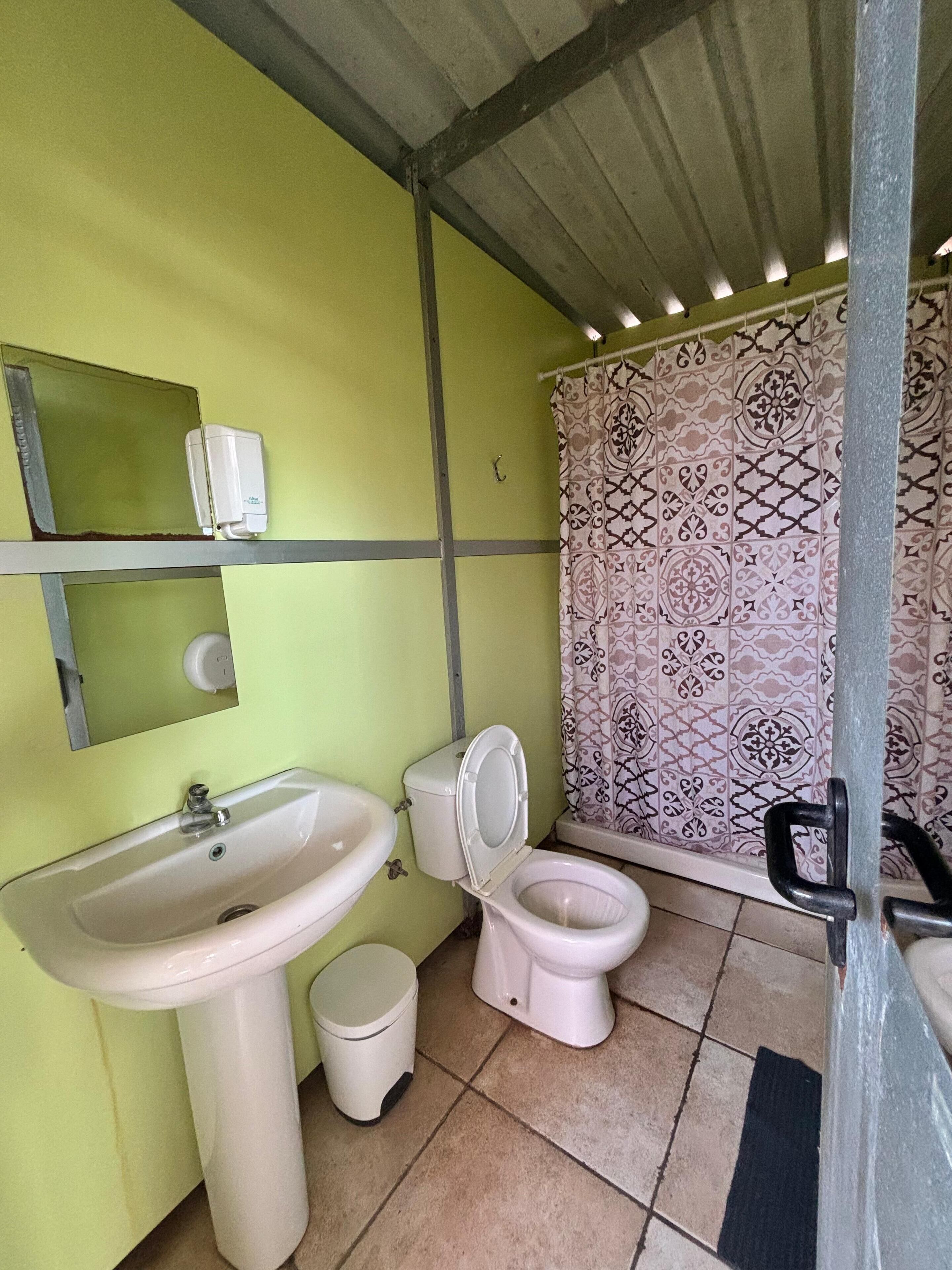 A small bathroom with a sink, toilet, and a mirror.