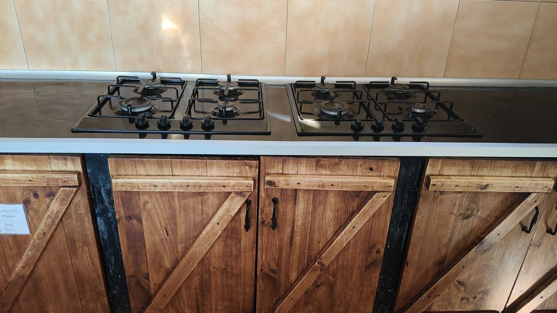 Een keuken met een gasfornuis en houten kastjes.