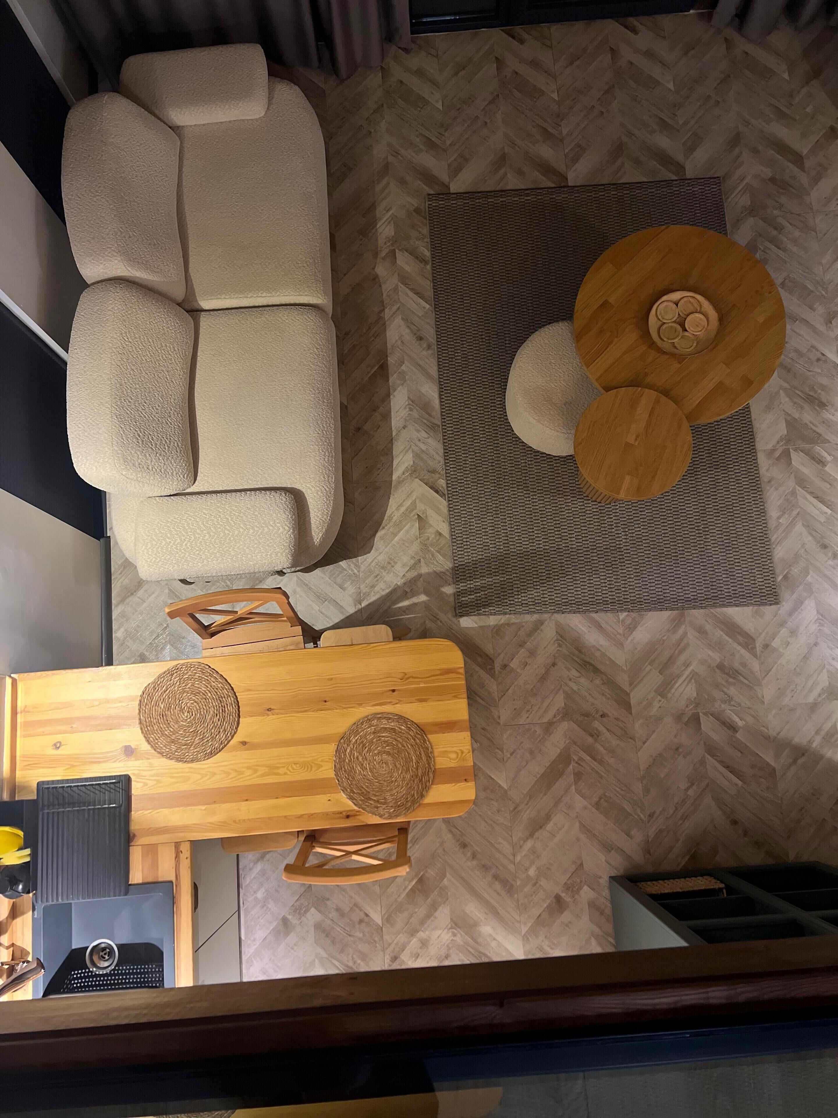 Uma sala de estar moderna com um sofá, uma mesa de centro de madeira e um tapete estampado.