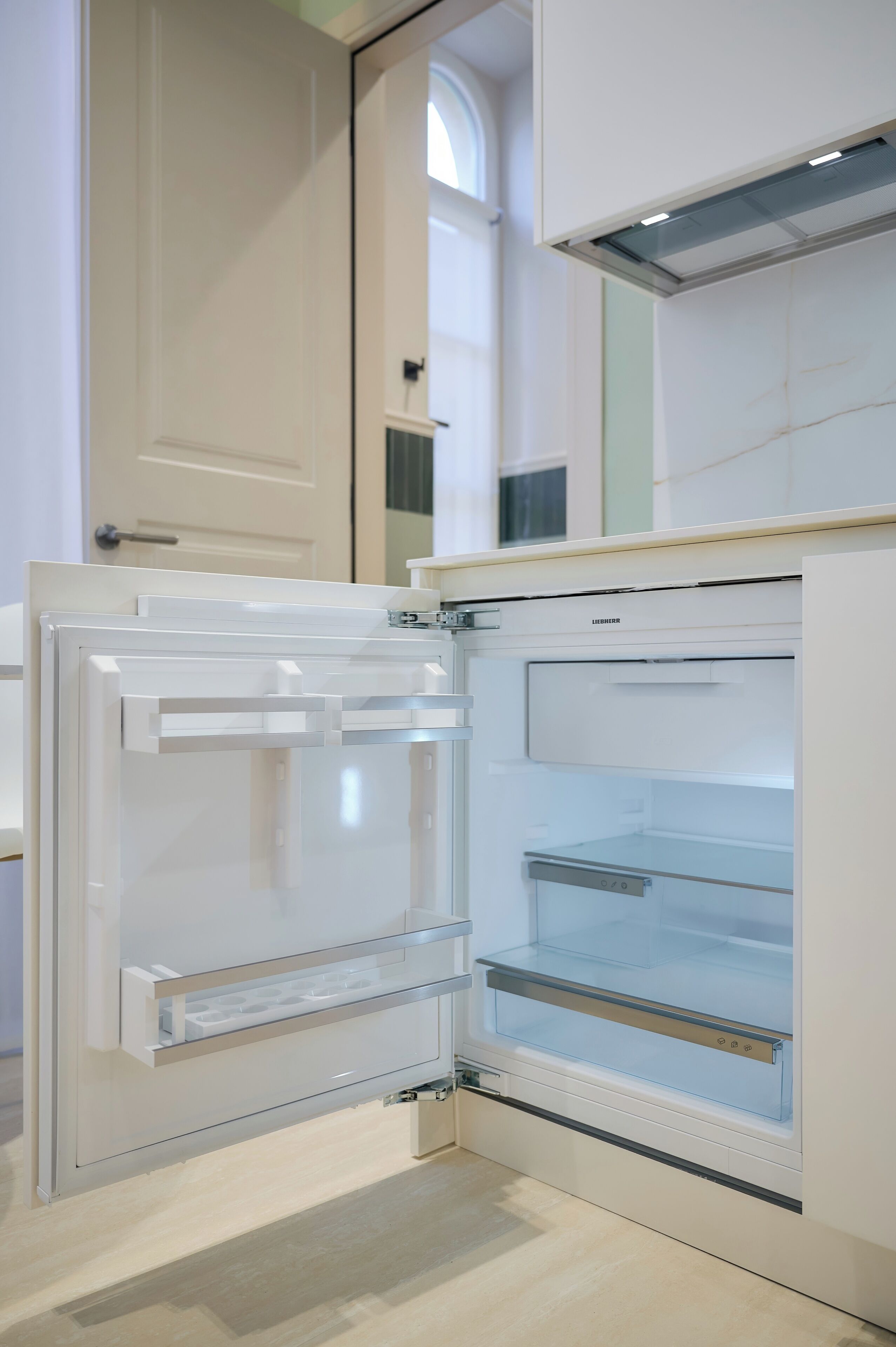 A modern kitchen with a built-in refrigerator and a microwave.