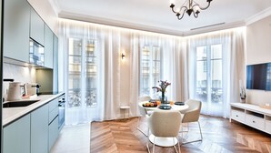 Una cucina moderna con zona pranzo, ampie finestre e un lampadario.