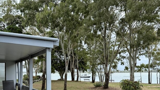 Un espace extérieur abrité offrant une vue sur un lac et des bateaux.