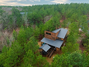 Eine moderne Hütte, umgeben von dichtem Wald.