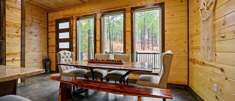 Un intérieur en bois avec une grande table à manger, des chaises et un banc.