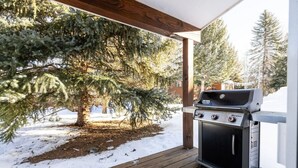 A covered outdoor area with a grill, wooden deck, and snow-covered ground. - Spacious Home Base! Hot Tub, Fire Pit, Sleeps 10 (Avon)
