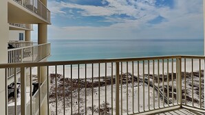 Ein Balkon mit Blick auf das Meer und den Strand.