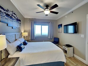 A hotel room with a large bed, a ceiling fan, a TV mounted on the wall, and a window with curtains. - The Beach Club - Avalon #1604 | Luxury Resort w. Pools, Pickleball, Gym + More (Fort Morgan)