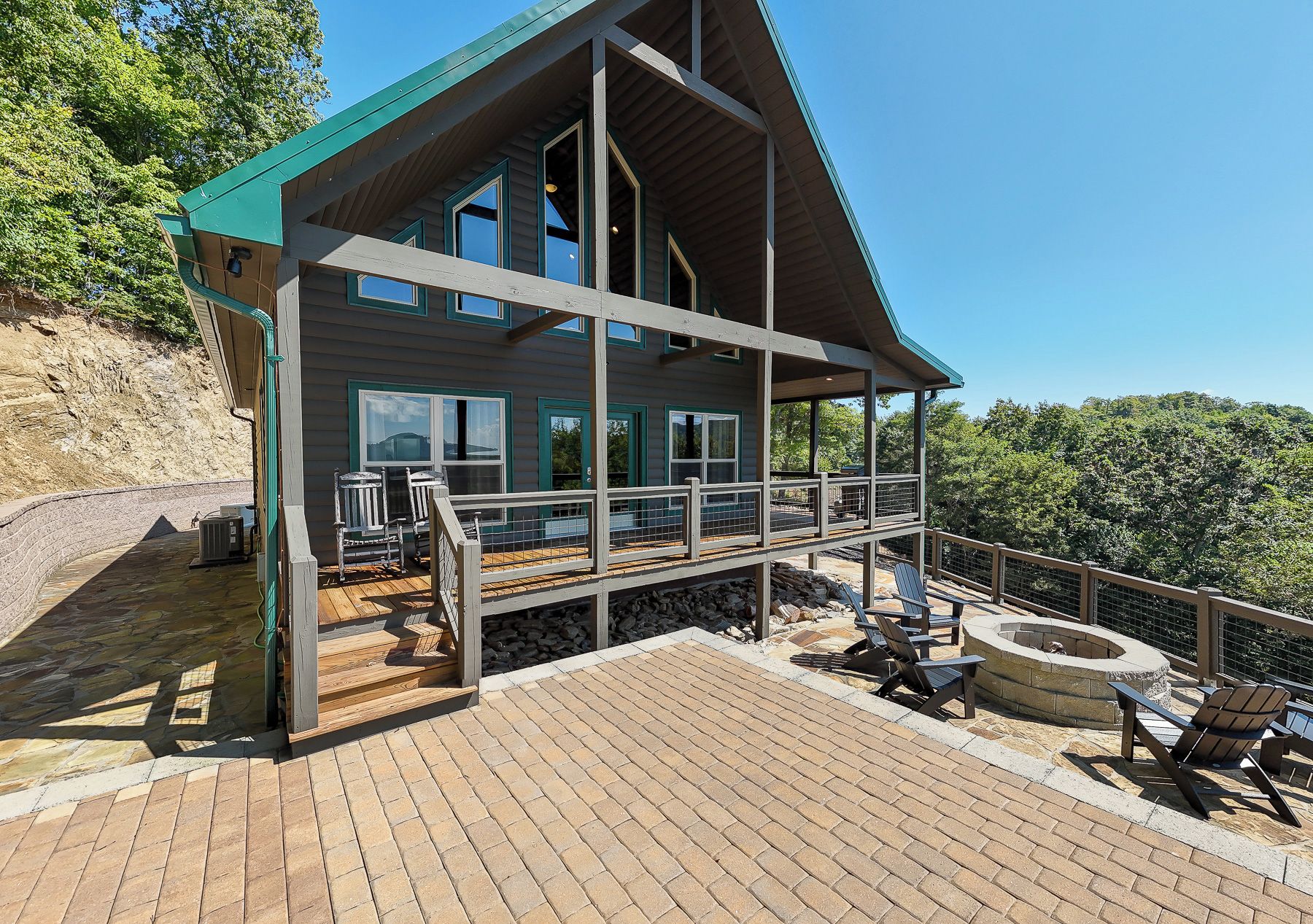 A two-story building with a balcony, outdoor seating, and a fire pit.