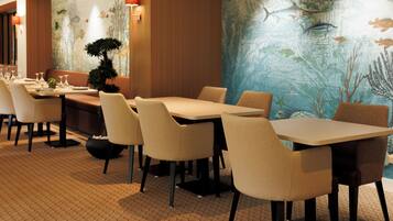 A restaurant with a long table, chairs, and a decorative wall mural.