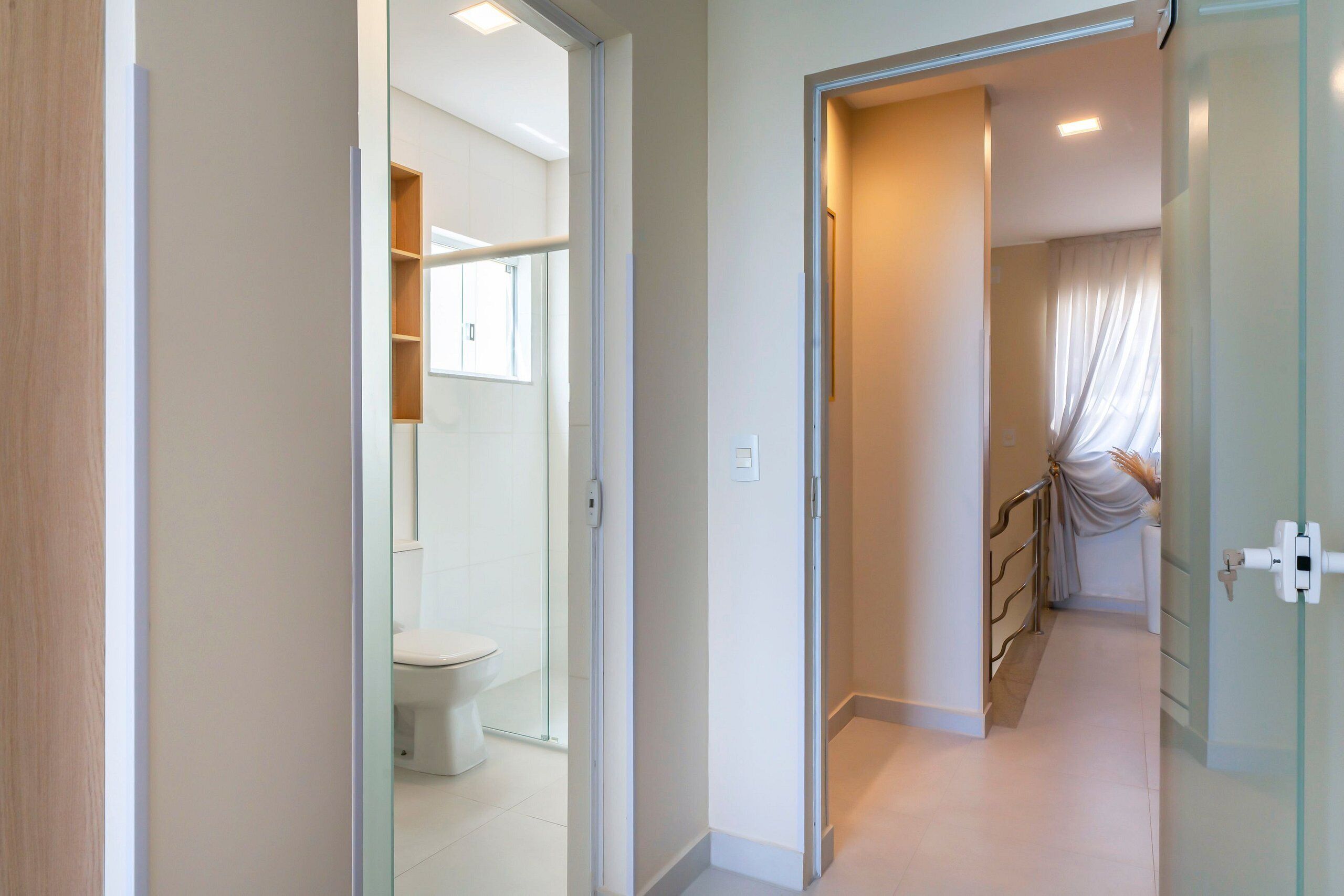 A modern bathroom with a toilet, shower, and glass-enclosed shower area.