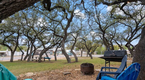 A park with picnic tables, a barbecue grill, and a fire pit.