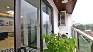 Ein Balkon mit Blick auf eine Stadtlandschaft, einer Waschmaschine und einem Blumentopf.