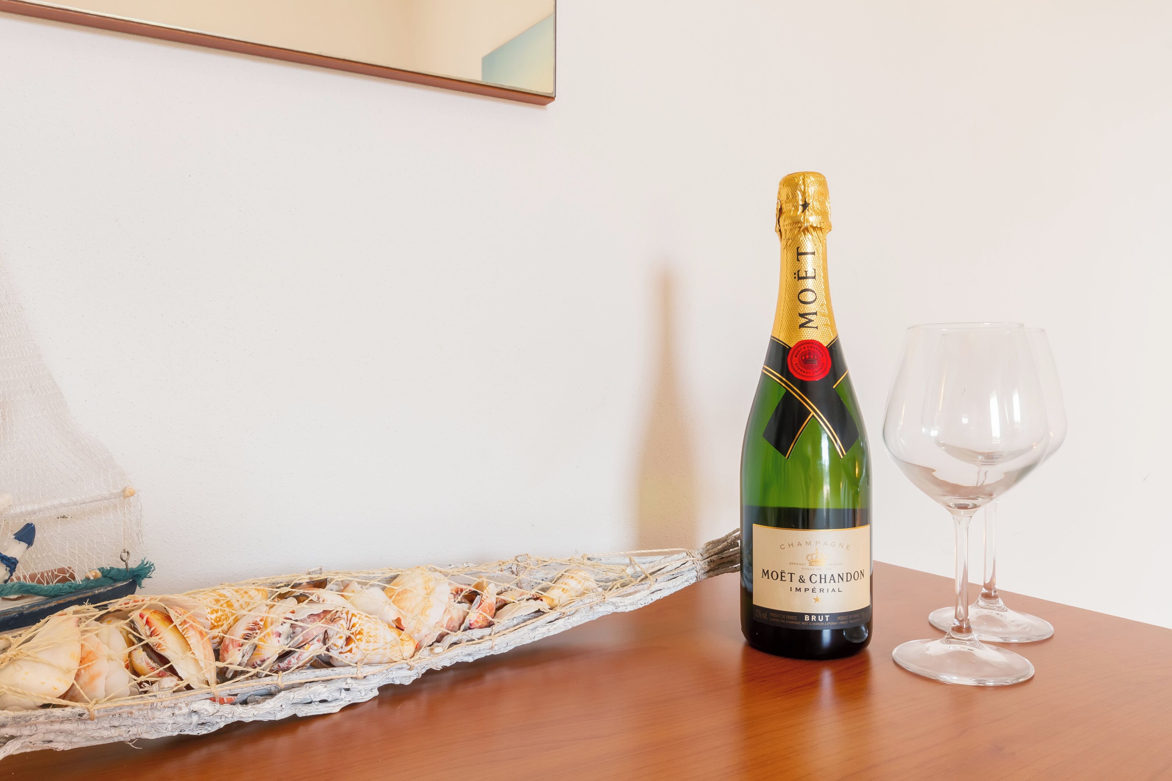 A bottle of Moët & Chandon champagne and a glass on a wooden table.