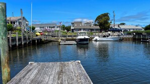 A wooden dock extending into calm water with a boat moored nearby.