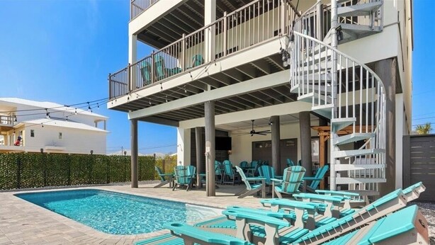 Un bâtiment à deux étages doté d’une piscine et de chaises longues.