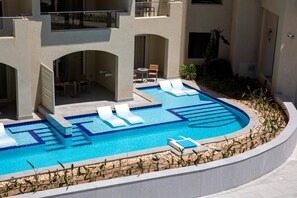A swimming pool with lounge chairs and a patio area. - SRNTY Sahl Hasheesh (Sahl Hasheeh)