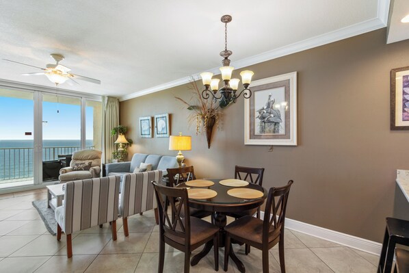 A dining area with a round table, chairs, and a chandelier. - San Carlos 1008 (Gulf Shores)