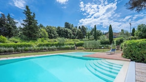 A rectangular swimming pool with a clear blue water surface, surrounded by well-maintained greenery and a stone deck. - Casa Viola Pool Wifi Montaione (Montaione)