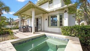 A house with a swimming pool, outdoor furniture, and a covered patio.
