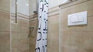 Ein Badezimmer mit Dusche, Toilette und Handtuchhalter.