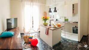 A modern living room with a TV, a wooden table, and a colorful rug. - Cycling Riviera apartment (Imperia)