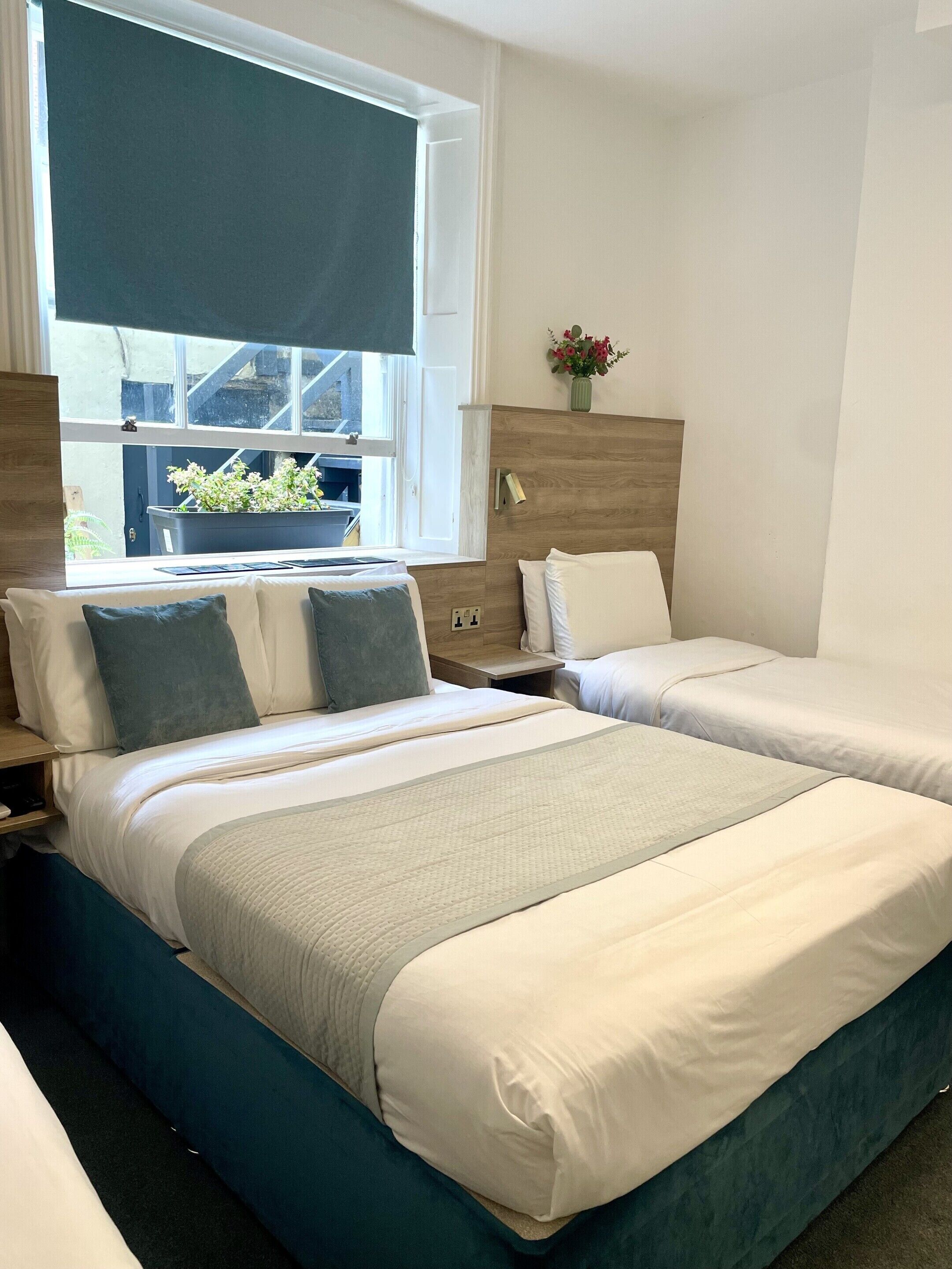 Habitación cuádruple ejecutiva, baño privado | Escritorio, tabla de planchar con plancha, wifi gratis