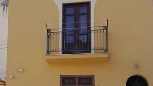 A two-story building with a balcony, a door, and a window. - DE MEO GUEST HOUSE APPARTAMENT (Castellammare del Golfo)