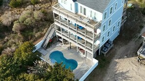 A multi-story building with a pool, surrounded by natural vegetation. - 5-bedroom house with private pool, spa and elevator near Rodanthe Pier (Rodanthe)