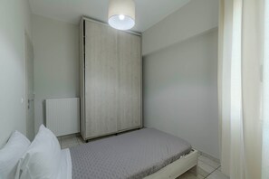 Una camera da letto con un letto, un termosifone e un armadio.