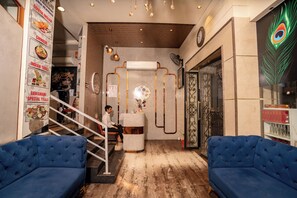 A hotel lobby with a staircase, a reception desk, and blue sofas. - Hotel Sawamani and Restaurant (Danta Ramgarh)