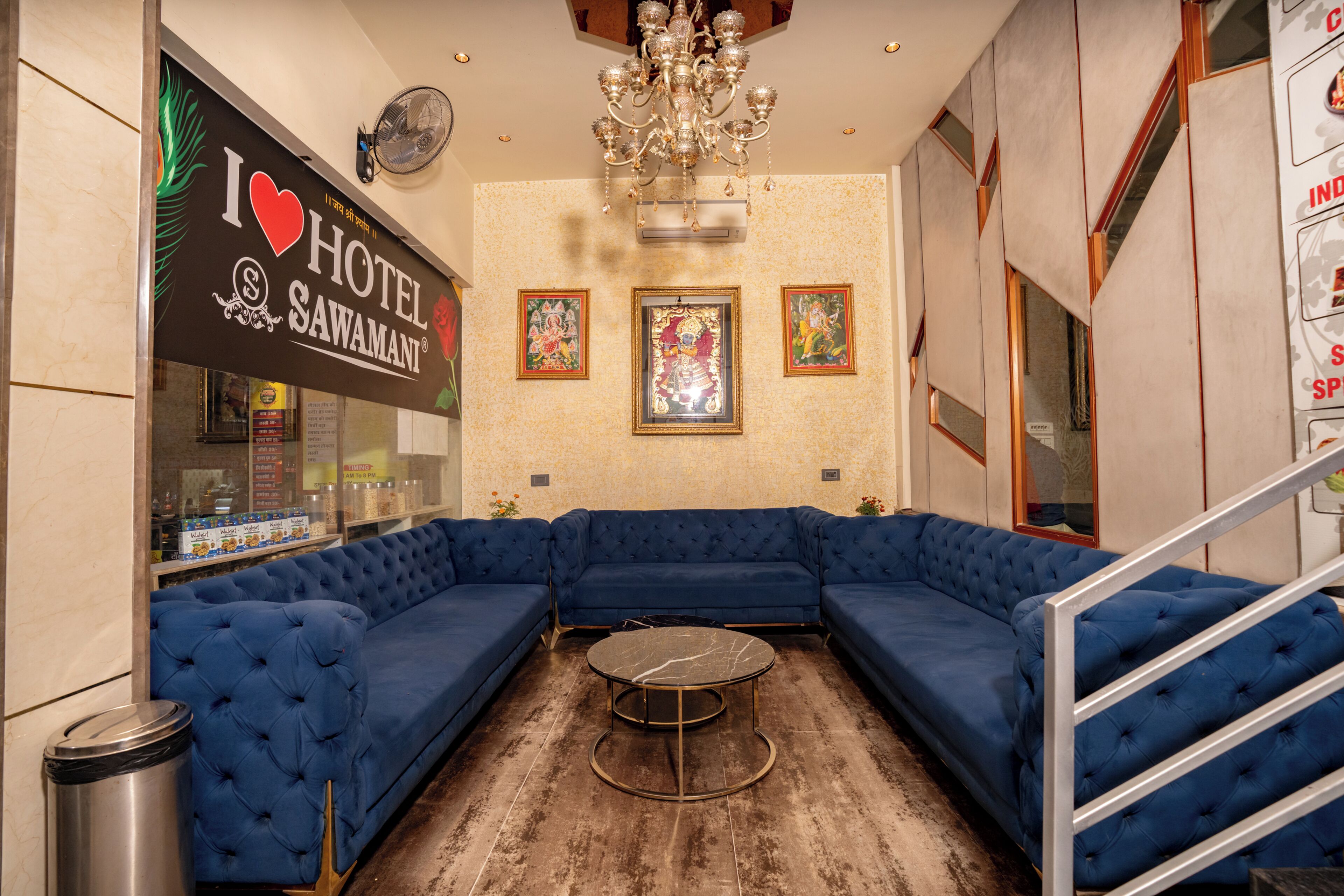 Eine Hotelhalle mit einem blauen, modularen Sofa, einem runden Tisch und einer Kronleuchter.