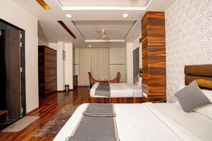 A hotel room with a bed, a desk, a chair, and a ceiling fan. - Hotel Sawamani and Restaurant (Danta Ramgarh)
