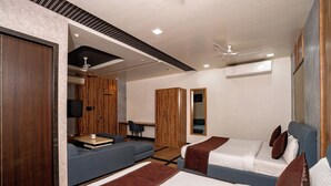 A modern hotel room with two beds, a sofa, a desk, and a TV. - Hotel Sawamani and Restaurant (Danta Ramgarh)
